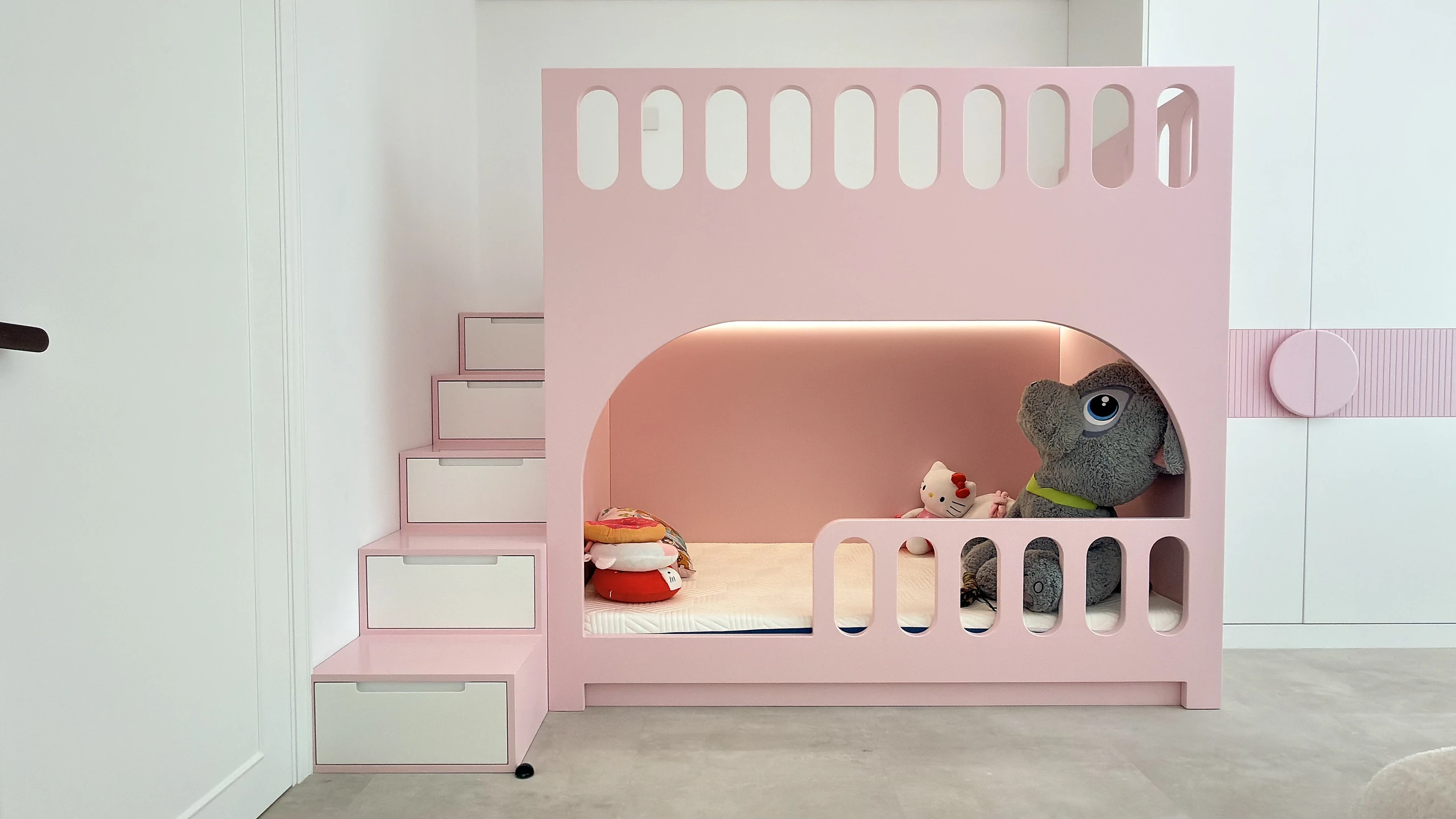 Bespoke pink bunk bed with staircase and play house frontage in a Dubai kids bedroom