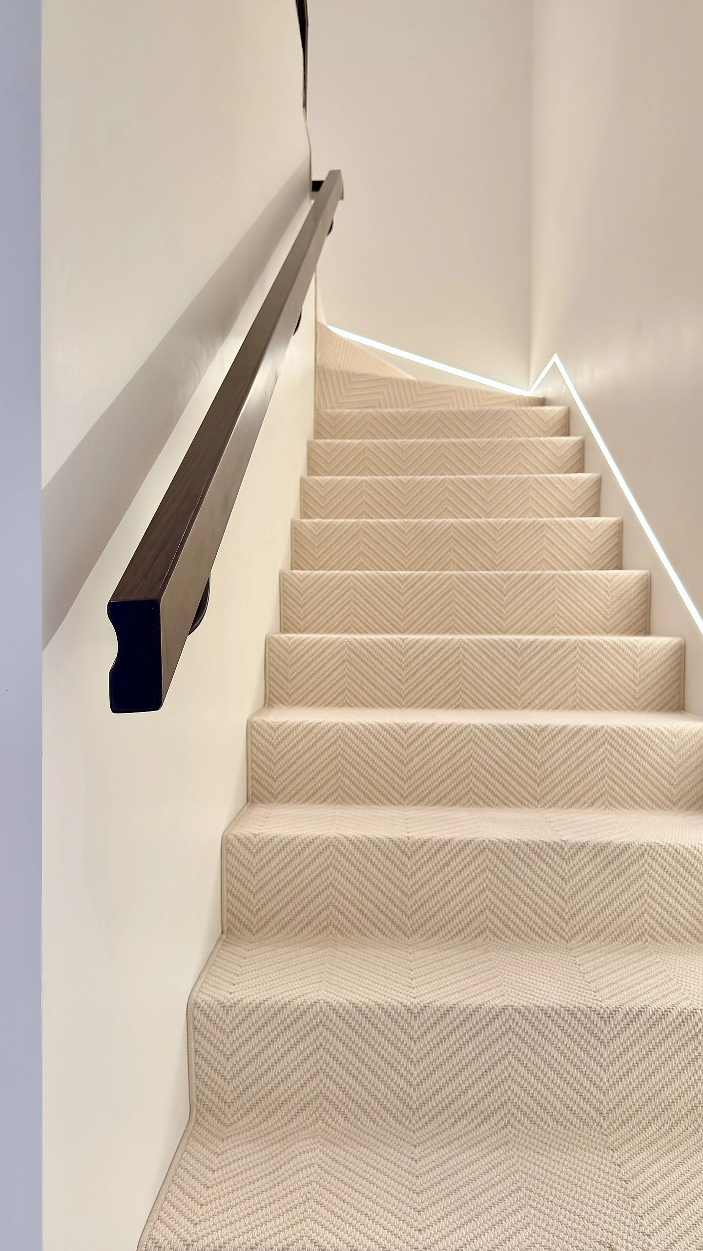 White oak staircase handrail with herringbone runner in a Dubai villa